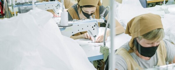 Mitarbeiter bei der Bekleidungsproduktion an industriellen Nähmaschinen