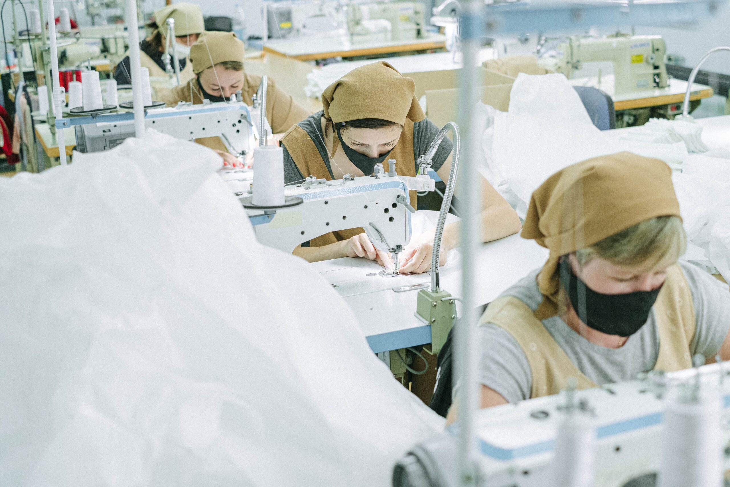 Mitarbeiter bei der Bekleidungsproduktion an industriellen Nähmaschinen